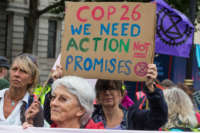 An environmental activist from Extinction Rebellion holds a sign calling for action at COP26 during the first day of Impossible Rebellion protests on August 23, 2021, in London, United Kingdom.