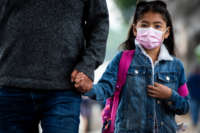 A father walks his daughter to Magnolia Avenue Elementary School in Los Angeles, California, on October 6, 2021.