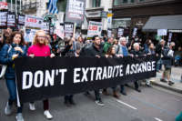 Protesters hold placards and a banner during a march from the BBC to Royal Courts of Justice in support of Julian Assange on October 23, 2021, in London, UK.