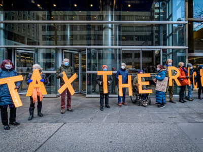 Demonstrators hold letters spelling “TAX THE RICH” outside then-Gov. Andrew Cuomo’s office in Manhattan, New York, on January 5, 2021.