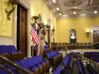 Jacob Chansley screams "Freedom" inside the Senate chamber after the U.S. Capitol was breached by a mob during a joint session of Congress on January 6, 2021, in Washington, D.C.