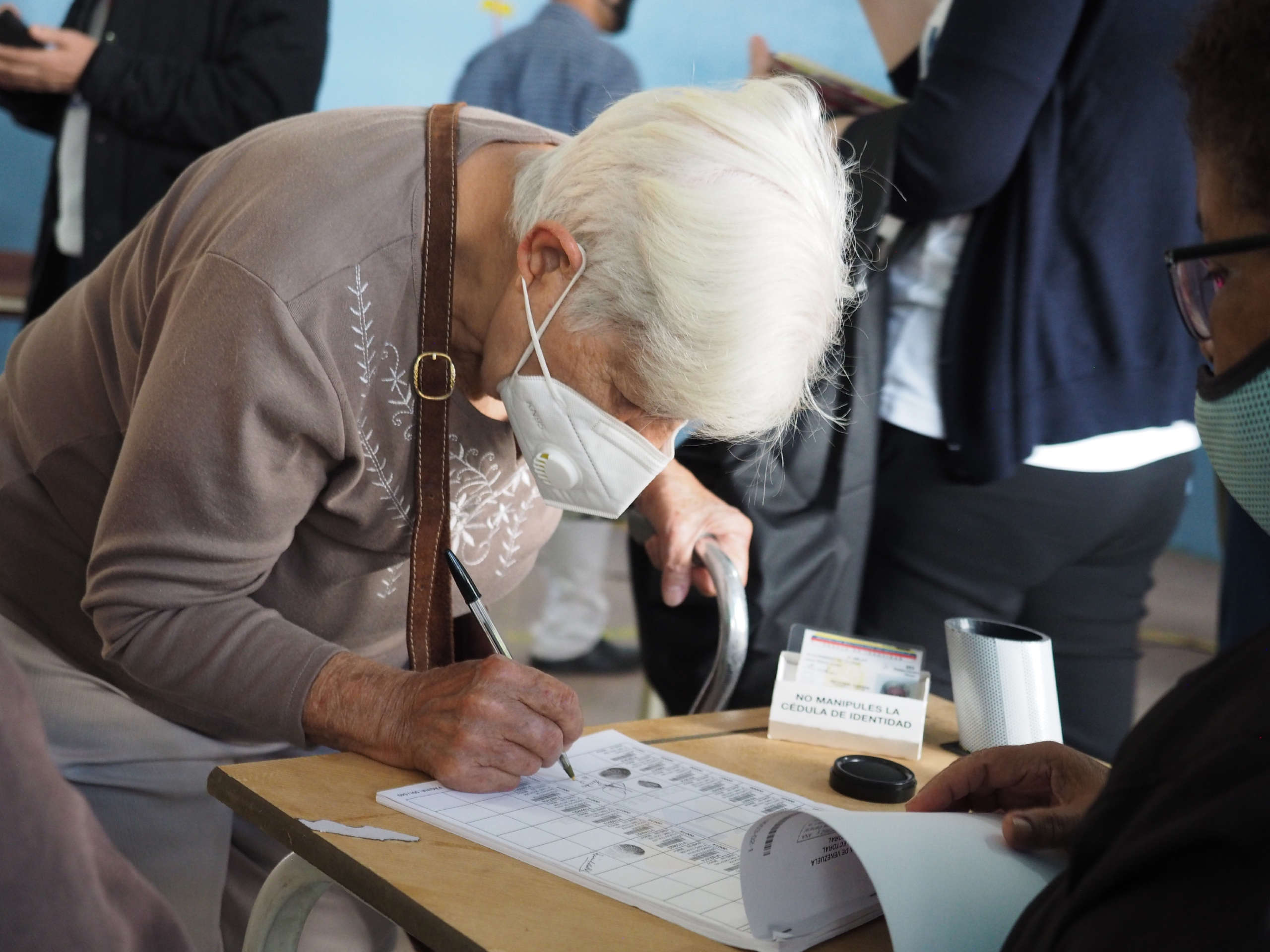 A woman signs her name as part of the voting process to prevent fraud at the Liceo Pedro Emilio Coll in the Coche Parish in Caracas, Venezuela during elections on November 21, 2021.