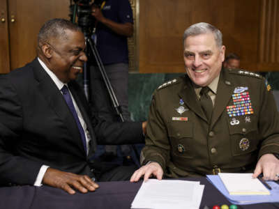 Defense Secretary Lloyd Austin, left, laughs with Chairman of the Joint Chiefs of Staff Gen. Mark Milley before their testimony at a Senate Committee on Appropriations hearing on the 2022 budget for the Defense Department