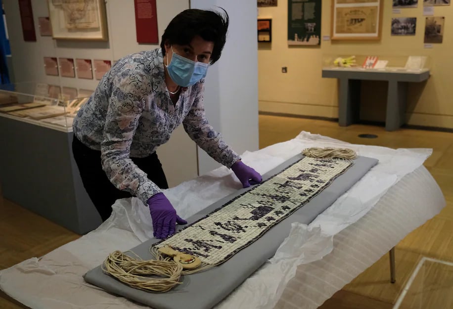 Co-curator Jo Loosemore looks at a wampum belt that was recently made by members of the Wampanoag tribe.