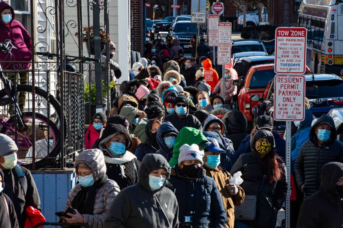 Hundreds of people wait in a line that stretched several blocks from the pantry for their turn to receive food at the La Colaborativa Food Pantry in Chelsea, Massachusetts, on November 23, 2021.