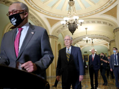Senate Minority Leader Mitch McConnell reacts after Senate Majority Leader Chuck Schumer walks in front of him to speak at a weekly news conference on August 3, 2021, in Washington, D.C.
