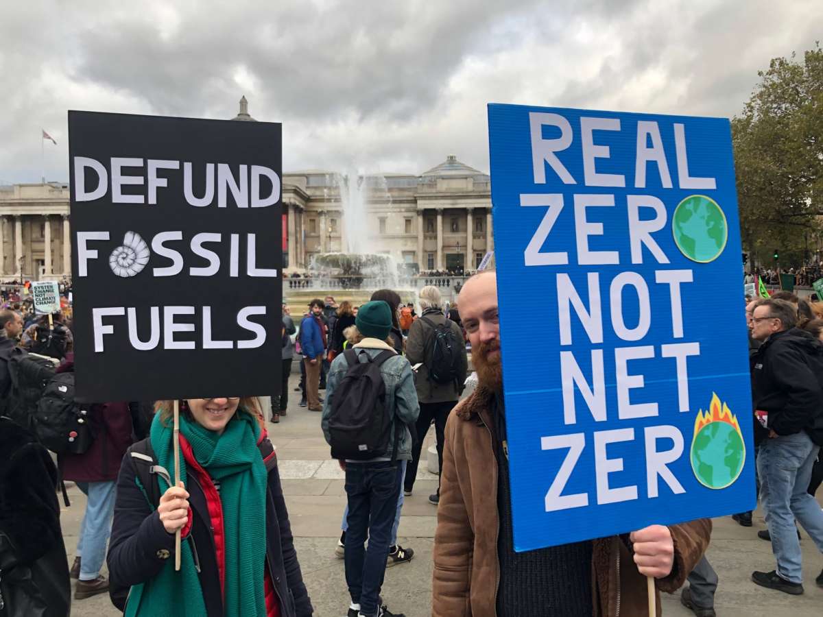 Two COP26 protesters hold signs calling for serious climate policy in London, U.K., on November 6, 2021.