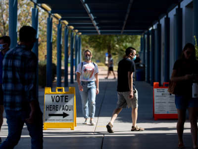 People walk around the entrance of a polling place