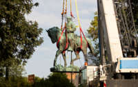 Workers remove the statue of Confederate General Robert E. Lee from a park in Charlottesville, Virginia, on July 10, 2021.