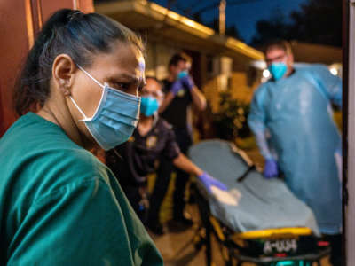 Houston Fire Department paramedics prepare to transport a woman who reported COVID symptoms to a hospital on August 25, 2021, in Houston, Texas.