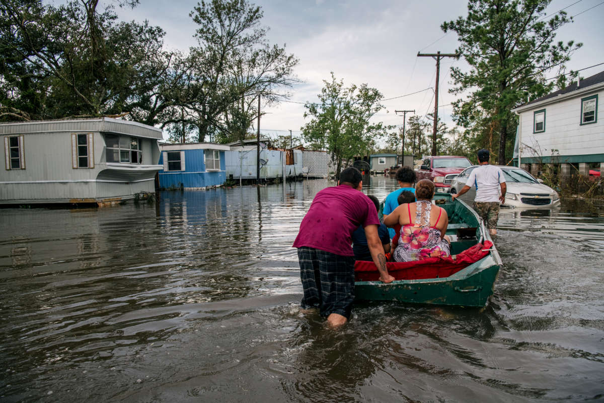 The Maldonado family travel by boat to their home after it was flooded during Hurricane Ida on August 31, 2021, in Barataria, Louisiana.