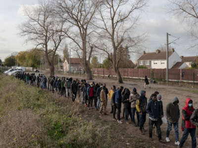 Refugees queue for food distributed by a local NGO on November 7, 2021, in Calais, France.