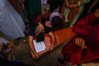 A relative weeping over the casket of a child killed by U.S. air strikes in Afghanistan