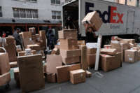 Dozens of packages are lined up along a Manhattan street as a FedEx truck makes deliveries on December 6, 2021, in New York City.