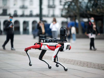 A Boston Dynamics robot walks across cobblestone