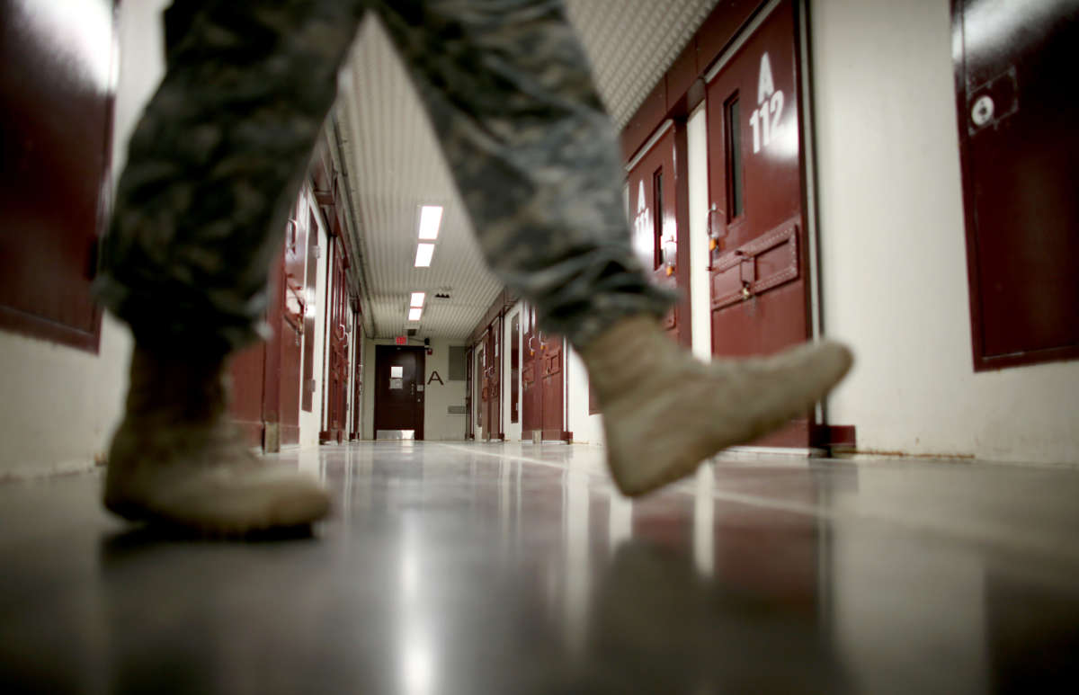 An officer walks through a prison cell block in Camp V where prisoners are housed in the single cell facility at the U.S. military prison for so-called enemy combatants on June 25, 2013, in Guantánamo Bay, Cuba.