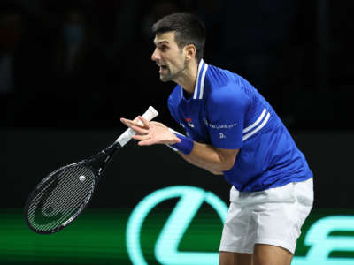 Novak Djokovic exclaims while holding a tennis racket