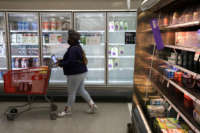 A shopper passes by depleted refrigerated shelves at a Target store on January 12, 2022, in Springfield, Virginia.