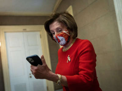 Speaker of the House Nancy Pelosi looks at her phone as she returns to her office after meeting with the family of George Floyd at the U.S. Capitol on May 25, 2021, in Washington, D.C.