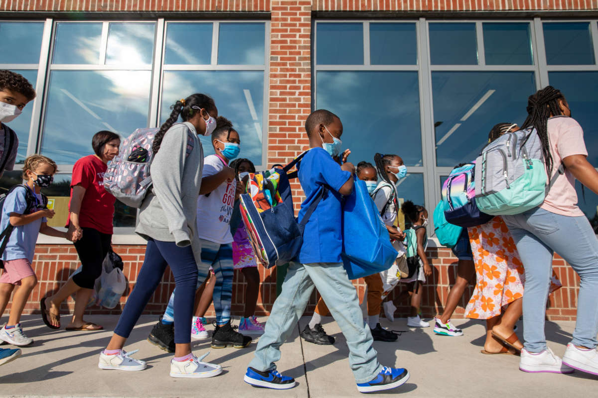 Students prepare to enter the building of Stratford Landing Elementary School in Alexandria, Virginia, on August 23, 2021.