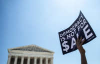 A sign reads Democracy Is Not For Sale, held up outside Supreme Court building during Citizens United protest