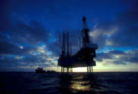 An oil drilling rig at sunset in the Gulf of Mexico.