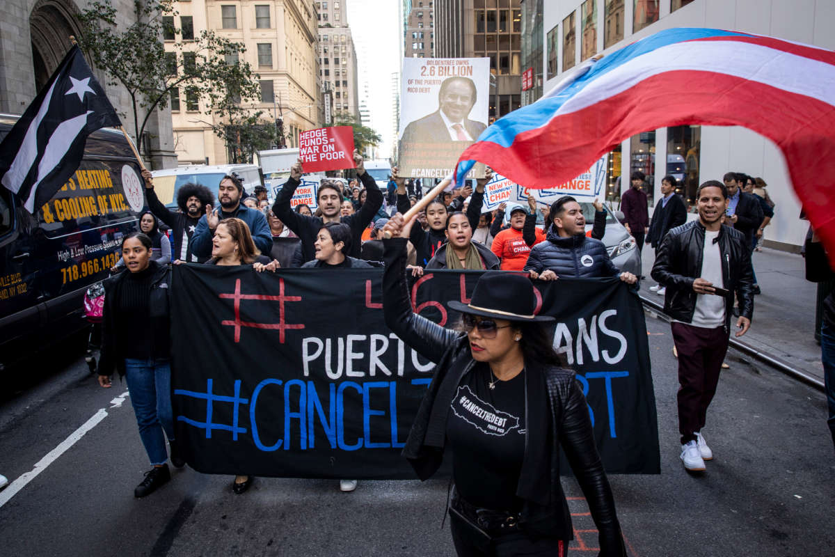 Activists and Puerto Rican community members protest against Steven Tananbaum, a board member of the Museum of Modern Art (MOMA), for his involvement in a hedge fund that owns over $2 billion of Puerto Rico's debt, outside of the newly renovated and reopened MOMA in Midtown Manhattan on October 21, 2019, in New York City.