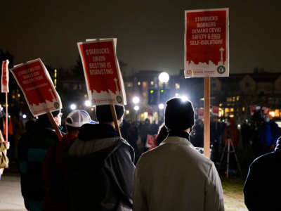 Representatives from local unions hold signs in support of workers of two Seattle Starbucks locations that announced plans to unionize, during an evening rally at Cal Anderson Park in Seattle, Washington, on January 25, 2022.