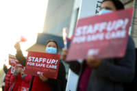 A registered nurse takes part in a rally outside the Kaiser Permanente Oakland Medical Center on January 13, 2022, in Oakland, California, in response to a California Department of Public Health decision to let asymptomatic, COVID-positive health care workers return to work without isolating or testing.