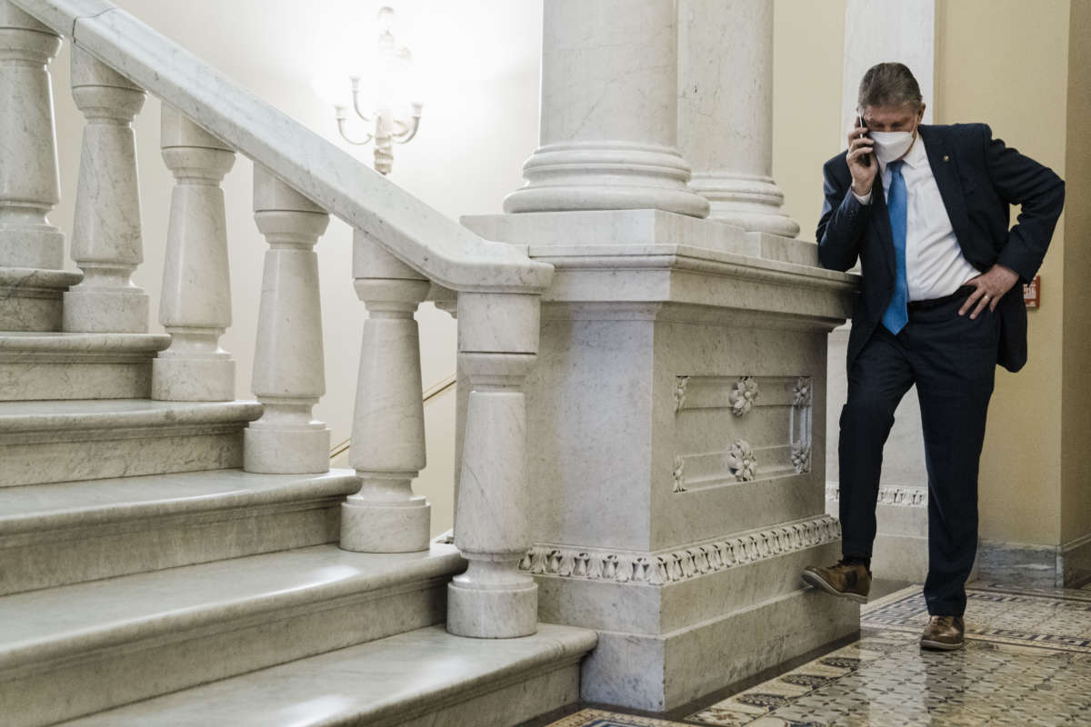 Sen. Joe Manchin on a phone call in a hallway just outside the Senate Chamber, after speaking on the floor of the Senate, on Capitol Hill on January 19, 2022, in Washington, D.C.