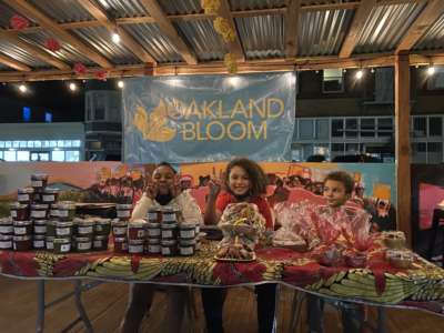 The children of participants in Oakland Bloom's incubator program at a neighborhood Small Business Saturday event selling items prepared by the chefs in December 2021.