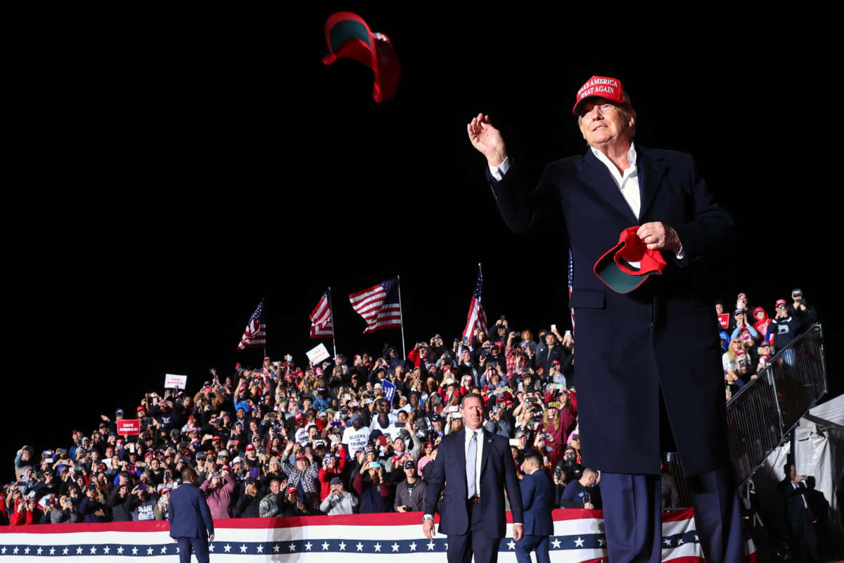 Former President Donald Trump tosses a MAGA hat to the crowd before speaking at a rally at the Canyon Moon Ranch festival grounds on January 15, 2022, in Florence, Arizona.