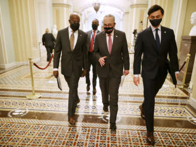 Senate Majority Leader Charles Schumer, center, walks with Sen. Raphael Warnock, left, and Sen. Jon Ossoff, right, on their way to a news conference at the U.S. Capitol on February 11, 2021, in Washington, D.C.