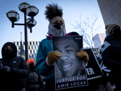 A demonstrator holds a photo of Amir Locke during a rally in protest of his killing, outside the Hennepin County Government Center in Minneapolis, Minnesota, on February 5, 2022.
