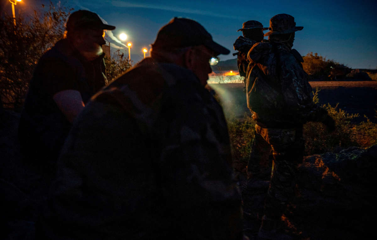 Militia members share cigarettes while patrolling the U.S.-Mexico border in Sunland Park, New Mexico, on March 20, 2019.