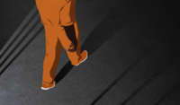 Prisoner in orange jumpsuits walks away from open prison cell bars, all casting long shadows ahead