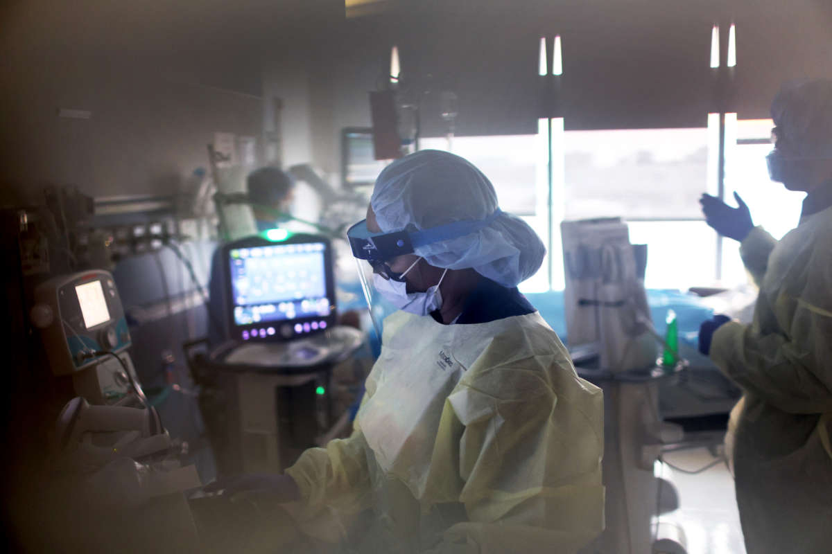 A respiratory therapist checks on a COVID-19 patient in the ICU at Rush University Medial Center on January 31, 2022, in Chicago, Illinois.