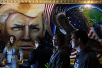 People walk by a portrait of President Donald Trump that was completed by artist Julian Raven at the Conservative Political Action Conference (CPAC) at Gaylord National Resort and Convention Center on March 1, 2019, in National Harbor, Maryland.