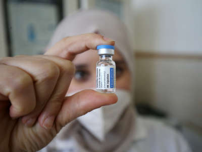 A medical worker prepares a dose of COVID-19 vaccine in Algiers, Algeria, on January 17, 2022.