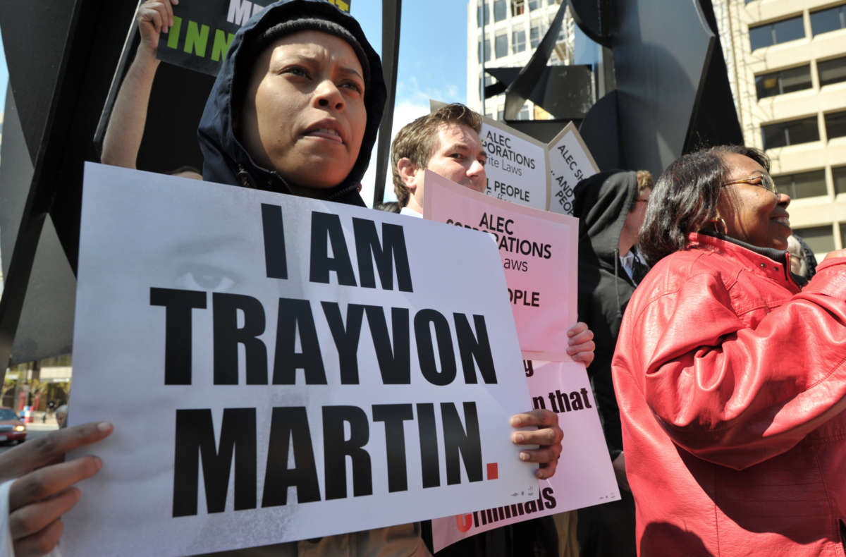 A protester carries a poster reading "I am Trayvon Martin"