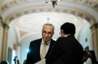 Senate Majority Leader Chuck Schumer speaks with an aide during a news conference following a Democratic policy luncheon on Capitol Hill on March 1, 2022, in Washington, D.C.