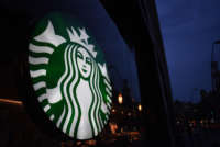 A Starbucks sign is pictured outside a store at night.