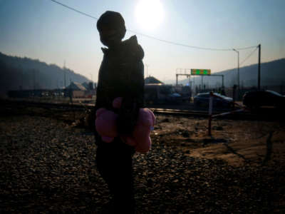 A young boy from Ukraine holds a pink teddy bear after crossing over a border point with his family in Kroscienko, in southeast Poland on March 19, 2022.