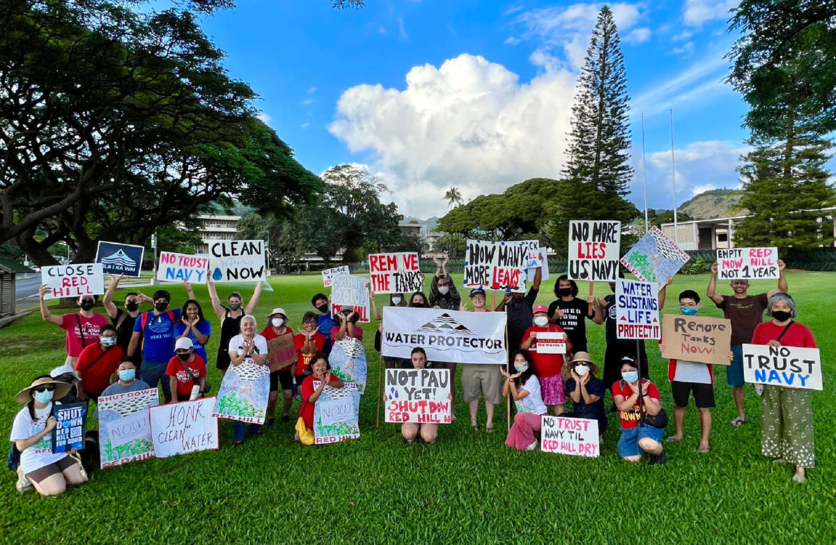 Oʻahu Water Protectors gather with signs protesting the U.S. Navy and the Red Hill bulk fuel station.