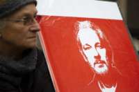 Protester for Julian Assange holds up sign