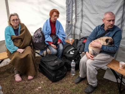 Kyiv residents sit in tent set up after building is hit with shrapnel