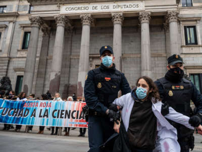 Police officers remove a climate activist of the Scientist Rebellion group from a protest in front of the Congress of Deputies in Madrid, Spain, on April 6, 2022.