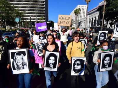 Activists march holding portraits of women who died because of the lack of legal right to abortion on International Women's Day, March 8, 2022, in Los Angeles, California.
