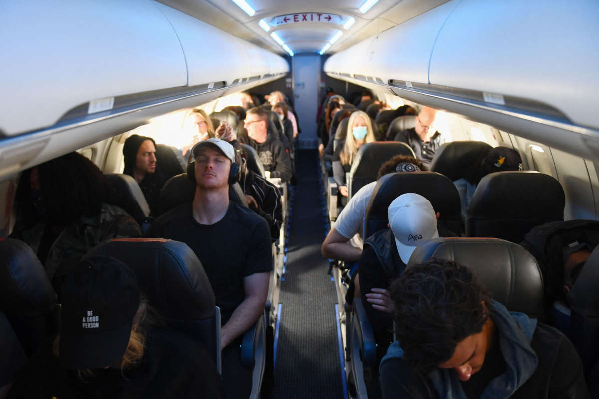 Airline passengers, some not wearing face masks following the end of COVID-19 public transportation rules, sit during a American Airlines flight operated by SkyWest Airlines from Los Angeles International Airport (LAX) in California to Denver, Colorado, on April 19, 2022.