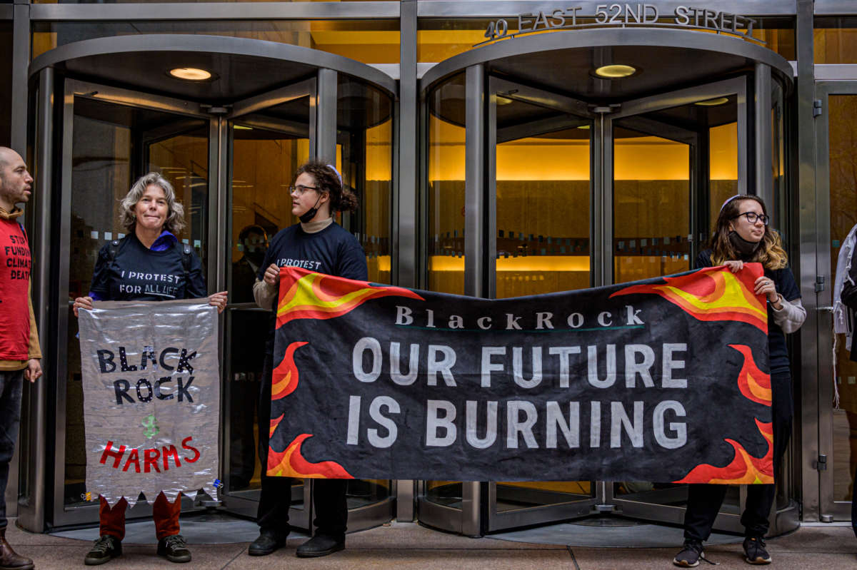 Participants hold a banner while blocking the doors at BlackRock headquarters in New York City on October 18, 2021.